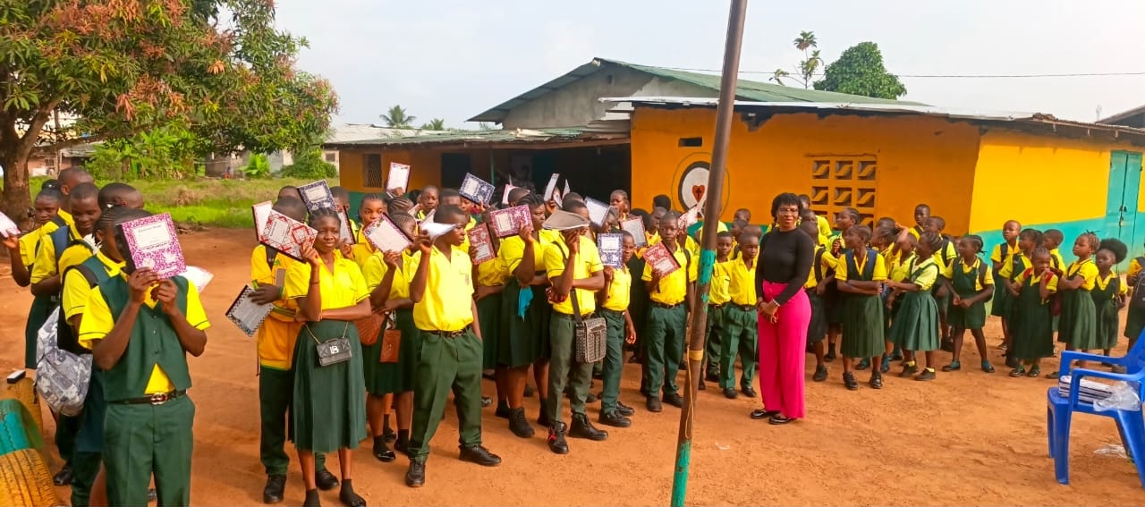 Students holding notebooks and school supplies during a distribution event